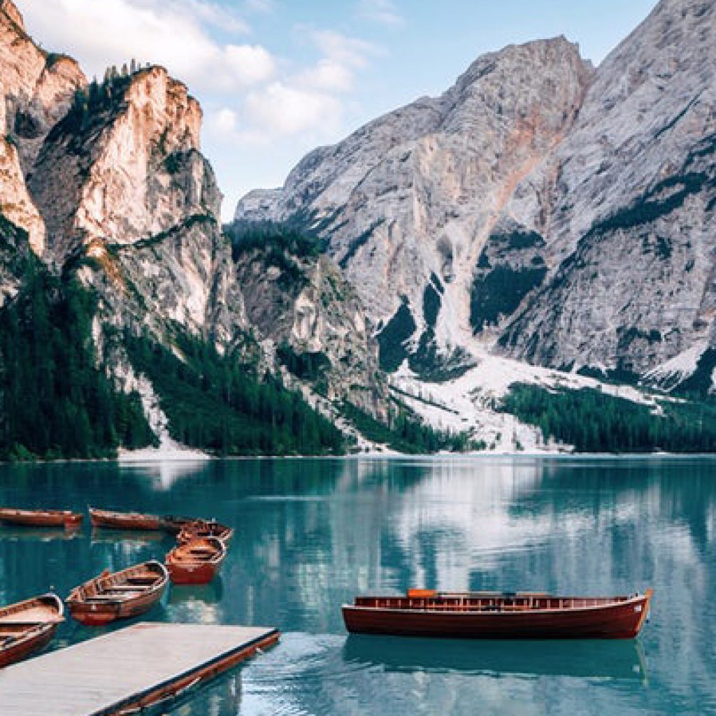 Wooden rowboats on turquoise alpine mountain lake